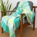 Green, white, lime green and tea check blanket displayed over a wooden chair