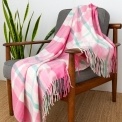 Check pattern in pink, white and teal blanket displayed over a wooden chair