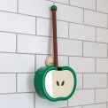Green apple-shaped toilet brush and holder with wall mount, displayed against white tiled wall.