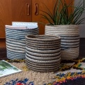 Set of three round jute striped jute baskets in assorted sizes.