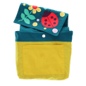 Inside of children’s backpack showing yellow lining, inner pocket, snap closure, and patterned flap