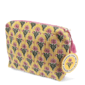 Yellow quilted wash bag with a pink and green flowers design and a tag.