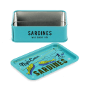 Open mini storage tin with the lid beside it, featuring an illustrated sardines on the lid.