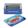 Open blue mini storage tin with the lid beside it, featuring an illustrated crab on the lid.