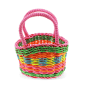 A small woven plastic basket with a pink handle and multicoloured striped body