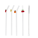 Four reusable glass drinking straws with colourful fruit toppers and cleaning brush