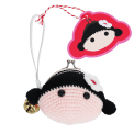 Crochet girl-shaped coin purse with a metal clasp and hanging bell charm with tag.