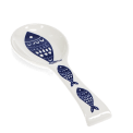 White ceramic spoon rest with blue fish design.