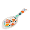 White ceramic spoon rest with a colourful fruit and leaf design.