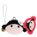 Crochet girl-shaped coin purse with a metal clasp and hanging bell charm with tag.