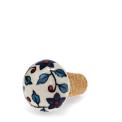 Ceramic and cork bottle stopper with floral and leaf pattern.