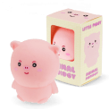 Pink pig-shaped squishy toy with smiling face, shown beside matching display box.