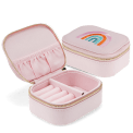 Open pink jewellery box with embroidered rainbow design, ring rolls and storage compartments.