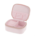 Open light pink jewellery box with ring rolls, storage compartments and interior pockets.