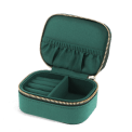 Open dark green jewellery box with ring rolls, storage compartment and interior pockets.