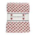 Hand block-printed throw with red floral pattern, folded in packaging.