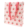 Light pink shopping bag with cherry print design and matching pink carry handles.