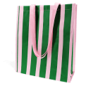 Shopping bag with bold green and pink vertical stripes and matching pink carry handles.