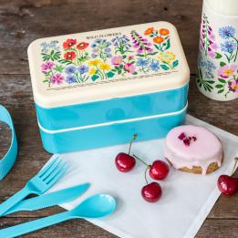 Turquoise plastic bento box with cream lid and middle tray featuring floral pattern