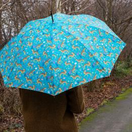 Turquoise umbrella with print of cheetahs used by person outside