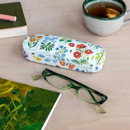 White hardshell glasses case with wild floral pattern on table