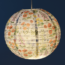 Paper lampshade with illustrations of wild flowers hung with light on shining through