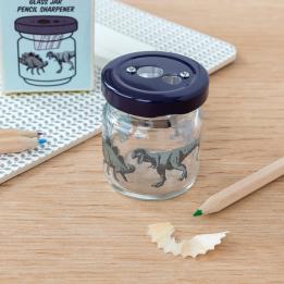 Glass jar pencil sharpener with dinosaurs print on desk with pencils