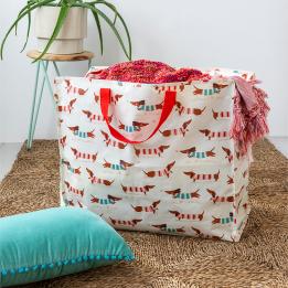 A large rectangular storage bag with red handles and a sausage dog pattern.