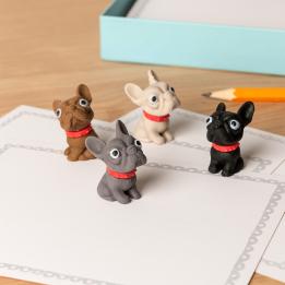 Four small erasers shaped like French Bulldogs in brown, white, grey, and black, each wearing a red collar.