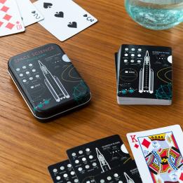 space-themed playing cards beside metal tin box