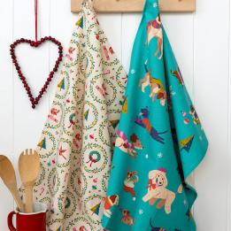 Cotton tea towel with a festive holiday design hanging on a hook