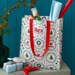 Christmas shopping bag with classic designs, filled with wrapping paper