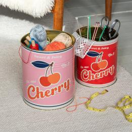 Two large cherry tins used for storing craft supplies.