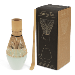 Matcha set with bamboo whisk, ceramic whisk holder, and scoop, displayed beside a labelled box 