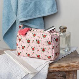 Rectangular makeup bag in pale pink with a floral pattern of small red and green flowers with tag