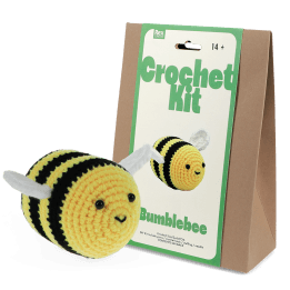 Crochet kit packaging and finished crocheted bee beside it