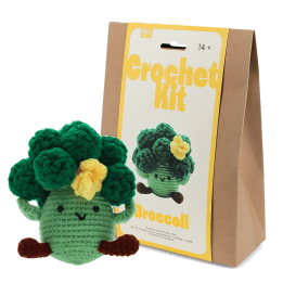 Crochet kit packaging placed beside finished crocheted broccoli