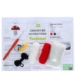 Crochet kit with yarns, hook, needle, stuffing, and instructions to make toadstool keyring