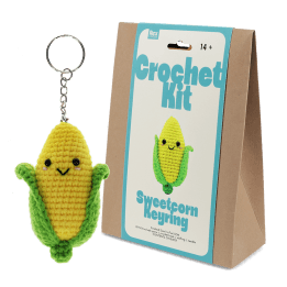 Crochet kit packaging displayed next to a finished yellow and green leaf sweetcorn keychain
