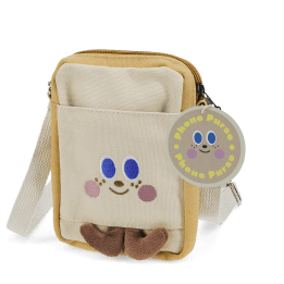 Beige and yellow crossbody bag with a front pocket featuring a smiling face design and two small brown plush feet at the bottom.