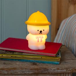 White bear night light wearing a yellow hat and pink neck tie shown with light on