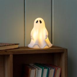 White ghost night light with black eyes, with its light turned on