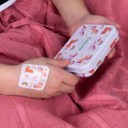 Plaster applied to a kid's hand with a unicorn-themed design.
