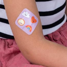 Plaster applied to a kid's arm with a kawaii sunshine-themed design.