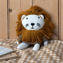 Knitted lion toy wearing a striped sweater, with white knitted legs