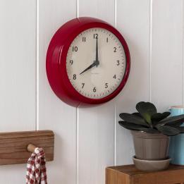 Round red wall clock with black hands and numbers,