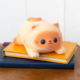 Squidgy stress cat lying on a book.