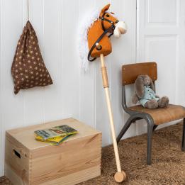 hobby horse toy with white mane and black bridle on a wooden stick