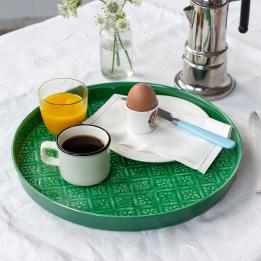 Round enamel trinket tray in dark green displayed with cup of coffee, orange juice and egg.