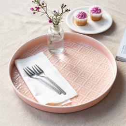 Round enamel trinket tray in soft pink displayed with fork and flower vase
